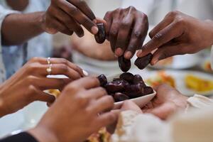 In a poignant close-up, the diverse hands of a Muslim family delicately grasp fresh dates, symbolizing the breaking of the fast during the holy month of Ramadan, capturing a moment of cultural unity photo