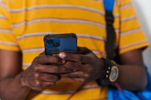 African American teenager engages with his smartphone against a pristine white background, encapsulating the essence of contemporary digital connectivity and youth culture photo