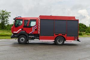 In this captivating scene, a state-of-the-art firetruck, equipped with advanced rescue technology, stands ready with its skilled firefighting team, prepared to intervene and respond rapidly to photo