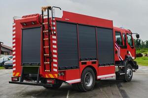 In this captivating scene, a state-of-the-art firetruck, equipped with advanced rescue technology, stands ready with its skilled firefighting team, prepared to intervene and respond rapidly to photo