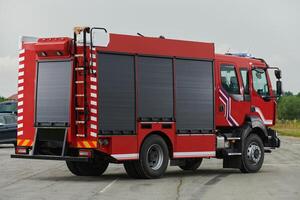 In this captivating scene, a state-of-the-art firetruck, equipped with advanced rescue technology, stands ready with its skilled firefighting team, prepared to intervene and respond rapidly to photo