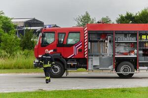 A firefighter meticulously prepares a modern firetruck for a mission to evacuate and respond to dangerous situations, showcasing the utmost dedication to safety and readiness in the face of a fire photo