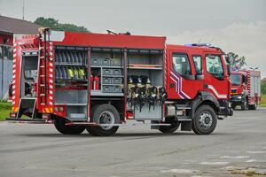 In this captivating scene, a state-of-the-art firetruck, equipped with advanced rescue technology, stands ready with its skilled firefighting team, prepared to intervene and respond rapidly to photo