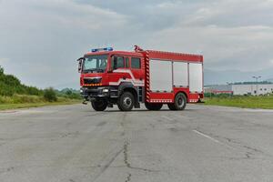 In this captivating scene, a state-of-the-art firetruck, equipped with advanced rescue technology, stands ready with its skilled firefighting team, prepared to intervene and respond rapidly to photo