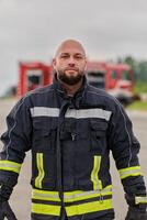 A symbolically brave firefighter strides forward with unwavering courage, epitomizing dedication and leadership, while behind him, a modern firetruck stands ready for firefighting actions, capturing photo