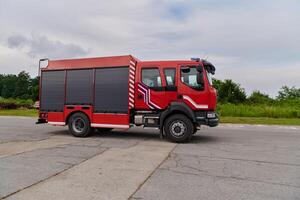 In this captivating scene, a state-of-the-art firetruck, equipped with advanced rescue technology, stands ready with its skilled firefighting team, prepared to intervene and respond rapidly to photo