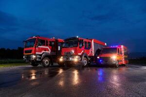A pair of highly modern and quality fire trucks illuminate the night with their rotating lights, symbolizing the cutting-edge technology and preparedness of the firefighting fleet, ready to respond to photo