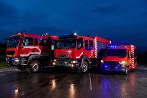 A pair of highly modern and quality fire trucks illuminate the night with their rotating lights, symbolizing the cutting-edge technology and preparedness of the firefighting fleet, ready to respond to photo