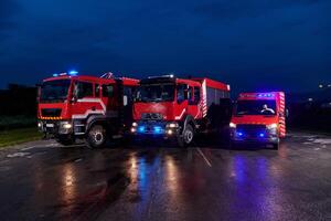A pair of highly modern and quality fire trucks illuminate the night with their rotating lights, symbolizing the cutting-edge technology and preparedness of the firefighting fleet, ready to respond to photo