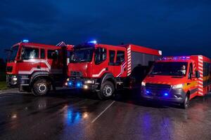 A pair of highly modern and quality fire trucks illuminate the night with their rotating lights, symbolizing the cutting-edge technology and preparedness of the firefighting fleet, ready to respond to photo