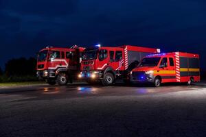 A pair of highly modern and quality fire trucks illuminate the night with their rotating lights, symbolizing the cutting-edge technology and preparedness of the firefighting fleet, ready to respond to photo