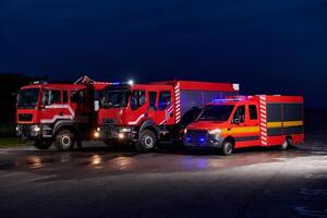 A pair of highly modern and quality fire trucks illuminate the night with their rotating lights, symbolizing the cutting-edge technology and preparedness of the firefighting fleet, ready to respond to photo