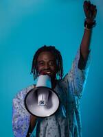 In a powerful and symbolic image, an African American man wears traditional clothing, passionately wields a megaphone against a striking blue background, with his hand raised in the air symbolizing photo