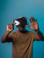 Immersed in a digital realm, an African American man navigates the virtual landscape with a VR goggles, using tactile gestures to interact with virtual objects, showcasing a harmonious blend of photo