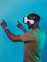 Immersed in a digital realm, an African American man navigates the virtual landscape with a VR goggles, using tactile gestures to interact with virtual objects, showcasing a harmonious blend of photo