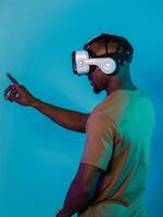 Immersed in a digital realm, an African American man navigates the virtual landscape with a VR goggles, using tactile gestures to interact with virtual objects, showcasing a harmonious blend of photo