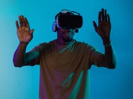 Immersed in a digital realm, an African American man navigates the virtual landscape with a VR goggles, using tactile gestures to interact with virtual objects, showcasing a harmonious blend of photo