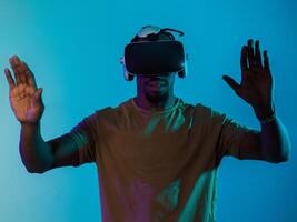 Immersed in a digital realm, an African American man navigates the virtual landscape with a VR goggles, using tactile gestures to interact with virtual objects, showcasing a harmonious blend of photo