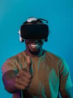 African American man wearing virtual reality glasses expresses satisfaction and impressed delight, gesturing with his hand pointed upward, while standing isolated against a vibrant yellow background photo