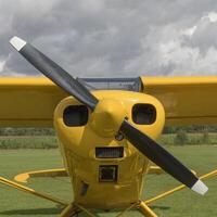 Front part of a light aircraft, yellow surface with a propeller. Square fomat. Close-up, screws, texture photo
