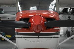 Front part of a light aircraft with a propeller. Close-up, screws, texture, red surface photo