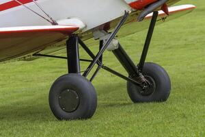 Chassis of a light sports aircraft on a grass field close-up photo