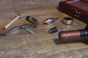 Set of accessories for bottled wine. Additional stoppers, means for opening, a corkscrew, a thermometer. On the texture table. Close-up. Place for text photo