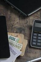 Banknotes in Euros and a fountain pen on a wooden table with an account book photo