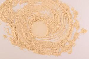 An empty round space on loose powder in a natural beige color. Advertising concept of the product. Top view. space for text. Beige background. photo