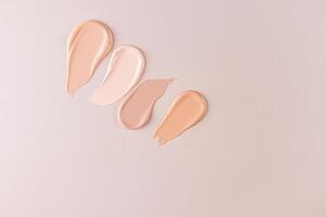 Cosmetic background with samples of foundation liquid powder in different tones, makeup. top view. texture samples for product advertising. photo