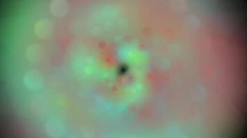a green and pink circular object with a black hole in the center video