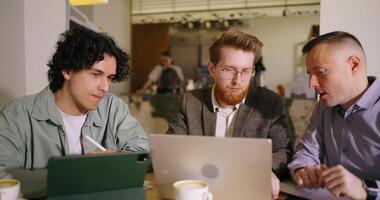 Teamwork And Brainstorming Of Creative Group Meeting In Cafe, Three Men Looking at Laptop Screen video