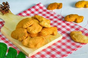 fish-shaped bahulu cake on a wooden cutting board. similar to a madeleine cake but in the shape of a fish photo