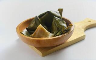 Bugis cake, traditional Indonesian food in the form of cake made from sticky rice flour filled with sweet grated coconut and wrapped in banana leaves. photo