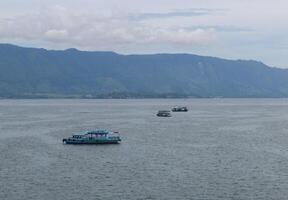 Lake Toba tourist boat sails on the waters of Lake Toba towards Samosir Island photo