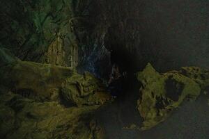 The beautiful views of the stalactite and stalagmite-filled cave in Lam Khlong Ngu National Park, Thailand. At the cave's exit is a small waterfall also. photo