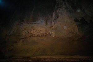The beautiful views of the stalactite and stalagmite-filled cave in Lam Khlong Ngu National Park, Thailand. At the cave's exit is a small waterfall also. photo