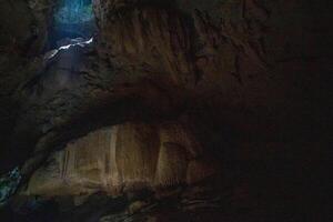The beautiful views of the stalactite and stalagmite-filled cave in Lam Khlong Ngu National Park, Thailand. At the cave's exit is a small waterfall also. photo