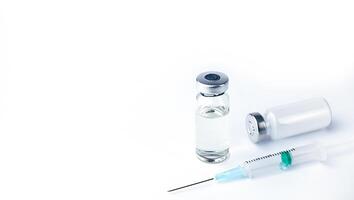 Vaccine vial, drug bottle and syringe injection on a white background. Vaccination, immunization, treatment to Covid-19. Top view. Close-up. Copy space. photo
