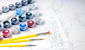 Canvas and paints of different colors, brushes. Painting by numbers. Creative hobby. Selective focus. Close-up. photo
