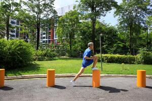 Senior Asian man is stretching his leg muscle during warm up exercise work out in the morning at public park for healthy and longevity photo