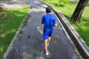 Senior Asian man is doing running exercise work out in the morning at public park for healthy and longevity concept photo