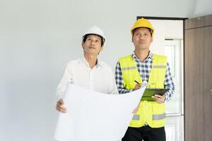 inspector or engineer is inspecting construction and quality assurance new house using a tablet. Engineers or architects or contactor work to build the house before handing it over to the homeowner photo