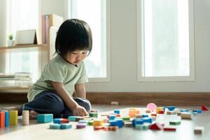 Happy Asia children play and learn toy blocks.family is happy and excited in the house. daughter having fun spending time, Activity, development, IQ, EQ, meditation, brain, muscles, essential skills. photo
