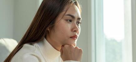 Depression and mental illness. Asian woman disappointed, sad after receiving bad news. Stressed girl confused with unhappy problems, arguing with boyfriend, cry and worry about unexpected pregnancy photo