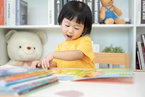 Happy Asian children relax read book at home. daughter and reading a story. learn development, childcare, laughing, education, storytelling, practice, imagine, reduce addiction mobile phone photo
