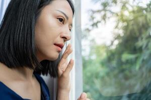 Depression and mental illness. Asian woman disappointed, sad after receiving bad news. Stressed girl confused with unhappy problems, arguing with boyfriend, cry and worry about unexpected pregnancy. photo