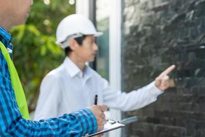 inspector or engineer is inspecting construction and quality assurance new house using a checklist. Engineers or architects or contactor work to build the house before handing it over to the homeowner photo