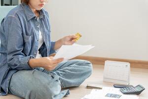 Stressed and headache asian woman with large bills or invoices no money to pay to expenses and credit card debt. shortage, Financial problems, mortgage, loan, bankruptcy, bankrupt, poor, empty wallet photo