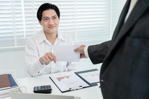Businessmen receive salary or bonuses from management or Boss. Company give rewards to encourage work. Smiling businessman enjoying a reward at the desk in the office. photo